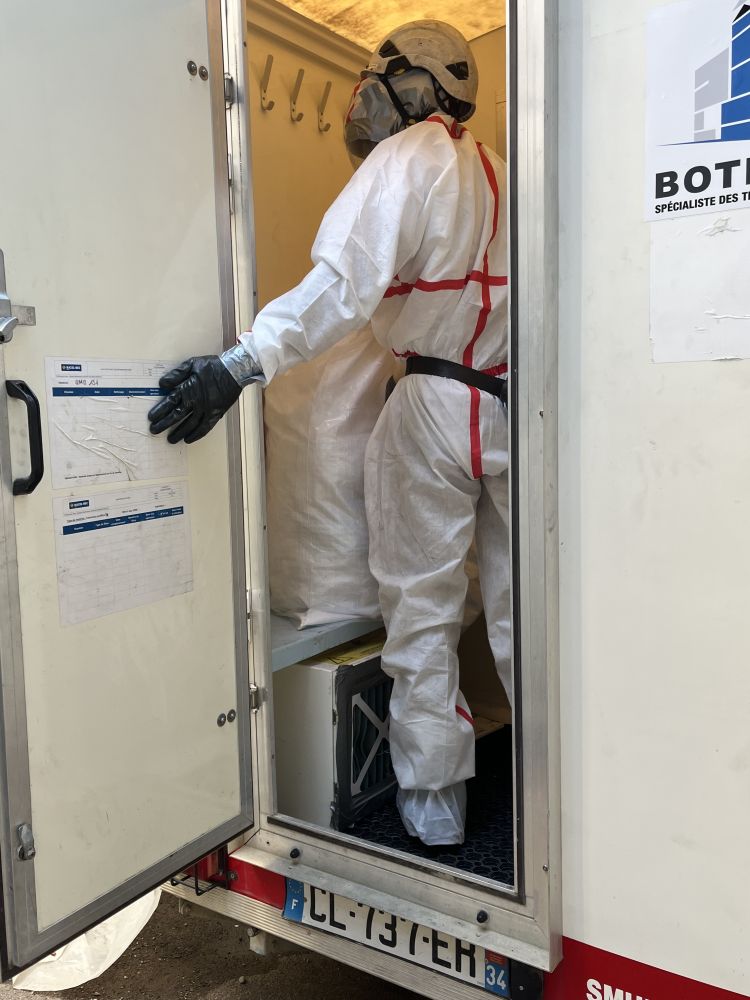 Technicien cordiste de BOTHIER entrant dans une Unité Mobile de Décontamination amiante